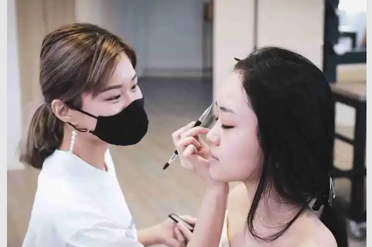a woman applying makeup to another woman