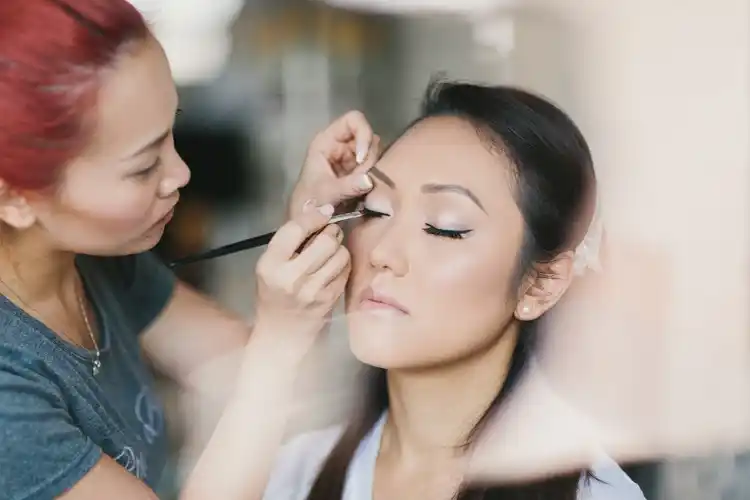 a woman getting her eye makeup done